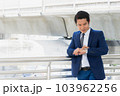 Asian businessman standing in town and see wrist watch. Look at working time checks. 103962256