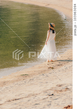 ペットボトルを持って歩く女性 103963094