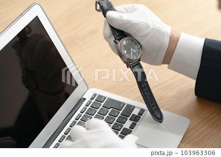 時計の鑑定をする男性　手元 103963306