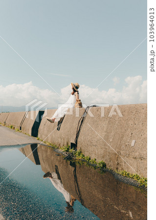 堤防に佇む女性 103964013