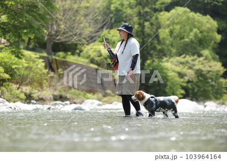 川遊びを楽しむ女性と犬の様子 川遊びを楽しむ女性と犬の様子 103964164