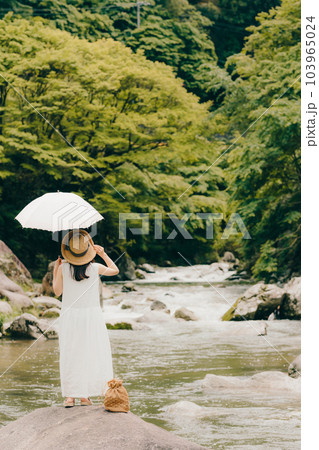 渓流で日傘をさして佇む女性 103965024
