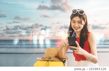 Southeast asian traveler woman using smartphone for travel on summer beach banner size background 103965126