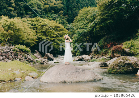 渓流でフィルムカメラを持って佇む女性 渓流でフィルムカメラを持って佇む女性 103965426