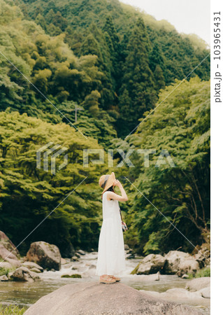 渓流でフィルムカメラを持って佇む女性 渓流でフィルムカメラを持って佇む女性 103965431