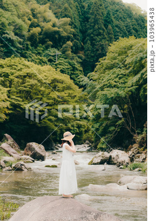 渓流でフィルムカメラを持って佇む女性 渓流でフィルムカメラを持って佇む女性 103965438