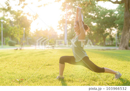 Female jogger. Fit young Asian woman with green sportswear stretching muscle in park before running and enjoying a healthy outdoor. Fitness runner girl in public park. Wellness being concept 103966532