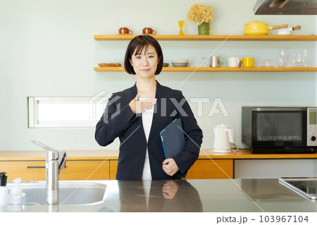 キッチンの紹介をする女性 103967104