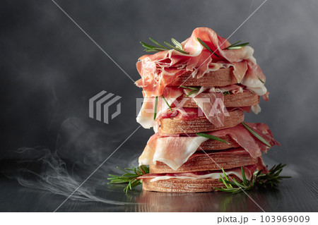 Italian prosciutto or Spanish jamon with bread and rosemary. 103969009