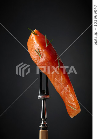 Smocked salmon on a black background. 103969047