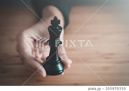 businessman hand holding black king of chess board ,team leader,  leadership and business strategy concept 103970350
