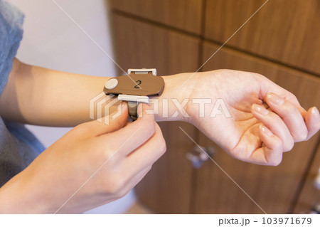 ロッカールーム鍵バンドをする若い女子手元 103971679