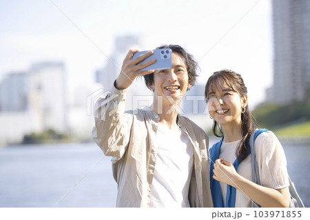 屋外で自撮りする若いカップル 103971855