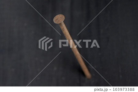 壁に刺さっている錆びた釘 壁に刺さっている錆びた釘 103973388