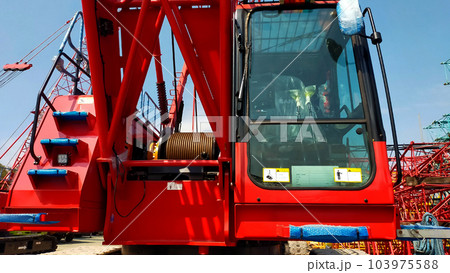 Small red crawler crane operator cabin boom anchor drum and side machine crane front look. Small red crawler crane operator cabin boom anchor drum and side machine crane front look. 103975588