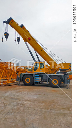 Yellow side view of yellow telescopic mobile crane boom up and park at the yard. Yellow side view of yellow telescopic mobile crane boom up and park at the yard. 103975593