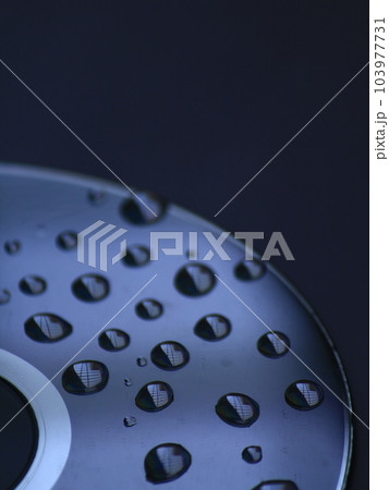 Water droplets on Compact disk. Blue background. Abstract concept Water droplets on Compact disk. Blue background. Abstract concept 103977731