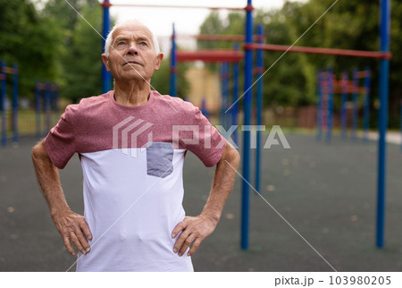 Elderly man standing on outdoor sports ground 103980205