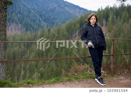 Young tourist girl on the top of the mounting landscape. Hiking woman relaxing. Caucasian beautiful woman wearing casual clothes, adventure traveling alone and hiking on the top of mountains in 103981584