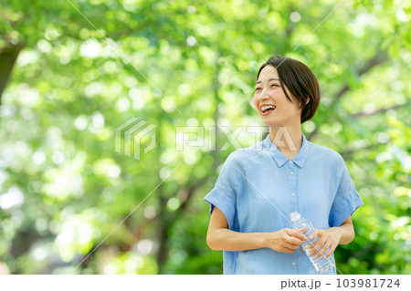 新緑の公園で水を飲む女性 103981724