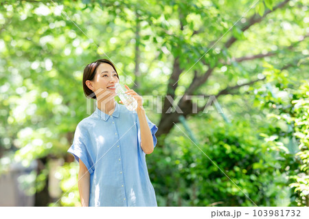 新緑の公園で水を飲む女性 新緑の公園で水を飲む女性 103981732