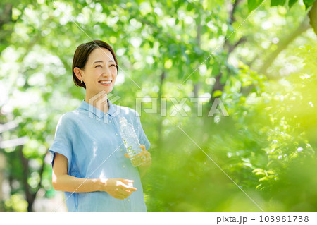 新緑の公園で水を飲む女性 新緑の公園で水を飲む女性 103981738