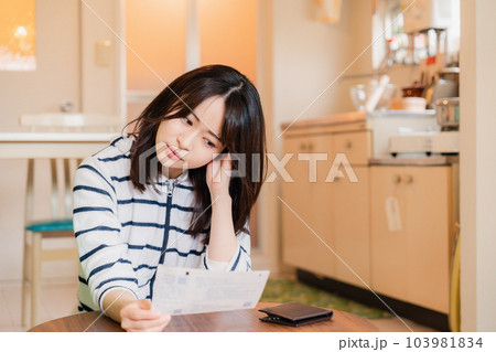電気料金の高騰で頭を抱える若い女性 電気料金の高騰で頭を抱える若い女性 103981834