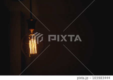 Glowing light bulb in the dark on wall and copy space for text. 103983444