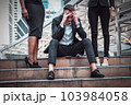 Caucasian businessman sit on the stairs and his hands clasped head, the feeling of stressed, sadness or displeasure. 103984058