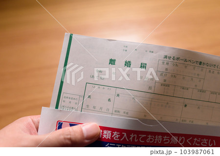 離婚届の書類を用意する男性 封筒から出す 離婚届の書類を用意する男性 封筒から出す 103987061