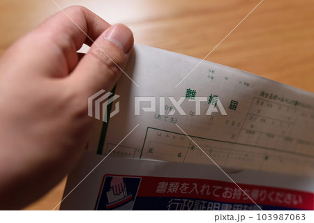 離婚届の書類を用意する男性　封筒から出す 103987063