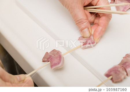 【焼き鳥豚タンの串打ちをする主婦】 103987160