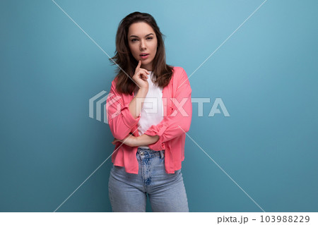 calm brunette young woman with shoulder-length hair in a pink shirt and jeans calm brunette young woman with shoulder-length hair in a pink shirt and jeans 103988229