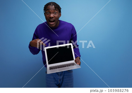 freelancer african young brunette man with dreadlocks with laptop 103988276