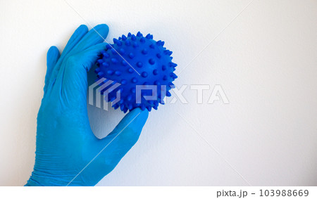 COVID-19 Pandemic Coronavirus concept. The doctor holds in his hand a abstract model of coronavirus. Gloved hand. 103988669