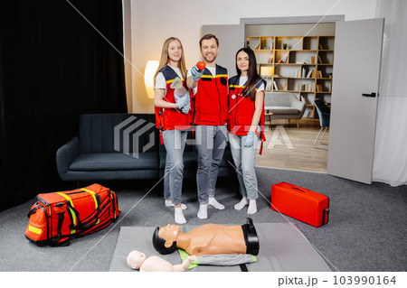 Group of people with cpr dummy looking at camera and smiling after first aid training class Group of people with cpr dummy looking at camera and smiling after first aid training class 103990164