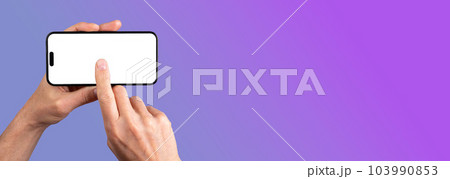 Lodz, Poland May 14 2023 hand holding iphone 14 pro max phone mockup, clicking on horizontal display mock-up. Banner background with copy space for text 103990853