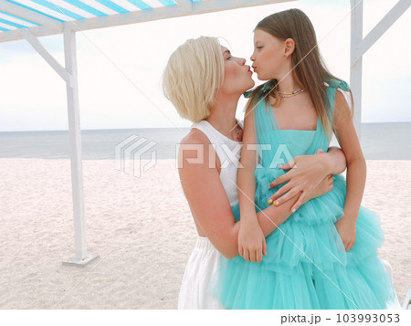 Mother and daughter having tender moment on the beach - Loving mom kissing her child outdoor - Family love concept Mother and daughter having tender moment on the beach - Loving mom kissing her child outdoor - Family love concept 103993053