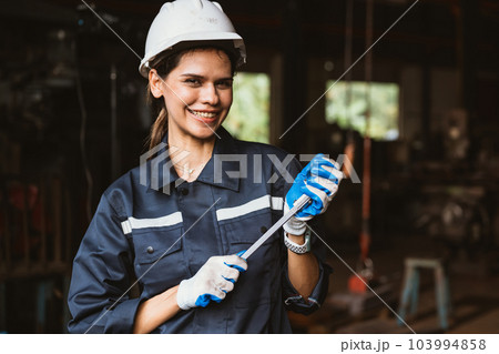 Portrait of happy female industrial worker in white hard hat smiling Portrait of happy female industrial worker in white hard hat smiling 103994858