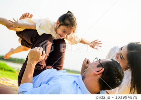 Happy family relaxing and resting in park together on weekend 103994878