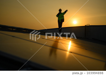 Silhouette of technician engineer checking and repairing solar panels Silhouette of technician engineer checking and repairing solar panels 103994898