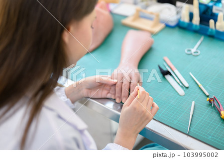 Technician making prosthetic device using grinder to smooth socket Technician making prosthetic device using grinder to smooth socket 103995002