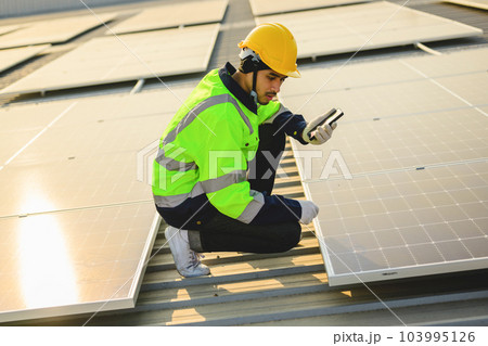 Engineer worker working at solar cell power plant with sunset 103995126