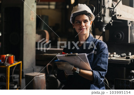 Portrait of happy female industrial worker in white hard hat smiling 103995154