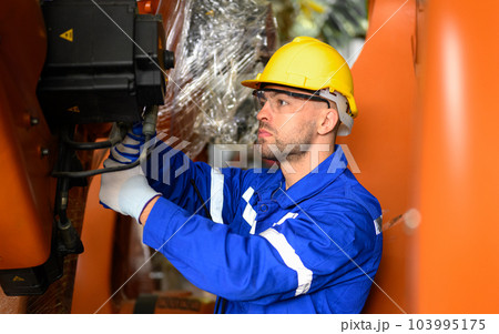 Professional maintenance worker with machine robotic arms at industrial factory Professional maintenance worker with machine robotic arms at industrial factory 103995175