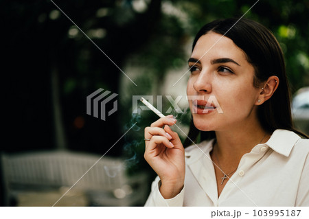 Young couple of man and woman smoking cigarette together Young couple of man and woman smoking cigarette together 103995187