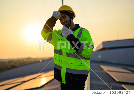 Worker with safety helmet checking and operating system at solar cell farm  103995424