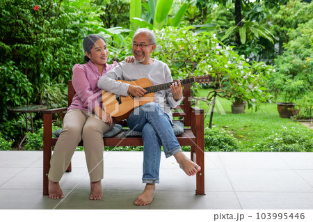 Happy senior grandparents playing guitar and singing songs having fun 103995446