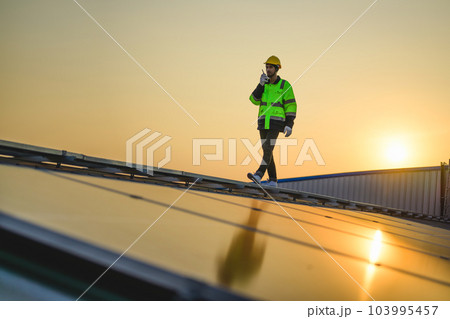 Engineer working at solar cell farm power plant with sunset in evening Engineer working at solar cell farm power plant with sunset in evening 103995457
