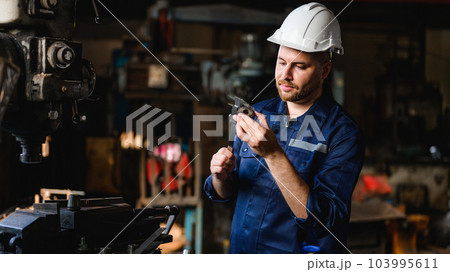Professional male technician checking and repairing machinery Professional male technician checking and repairing machinery 103995611
